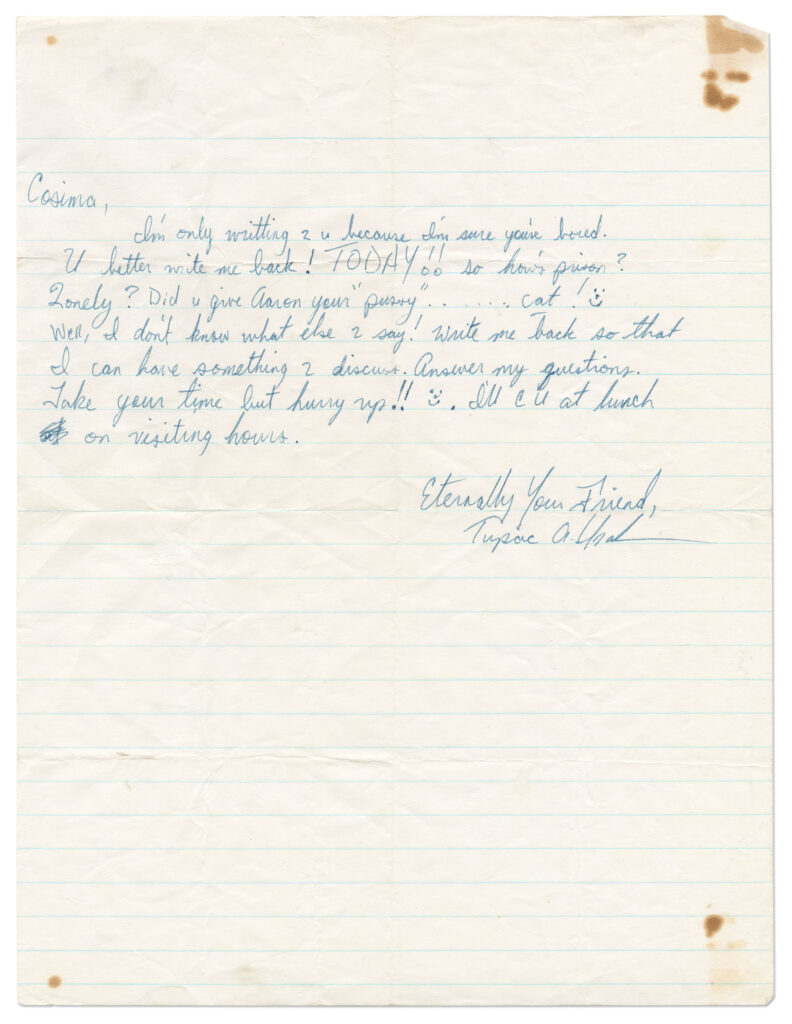 Tupac Shakur handwritten note on half a sheet of lined paper in blue cursive. Paper has some fold marks and stains.