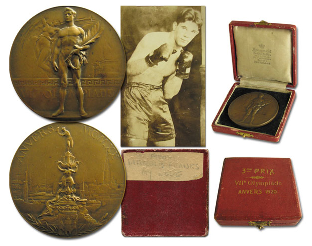 Bronze medal from the 1920 Antwerp Games that measures 2.5. inches in diameter. Front of medal is an etched Olympic athlete standing up and holding a winner's crown and palm leaf. Medal is pictured next to a photo of UK boxer Harold Franks, who won the medal.